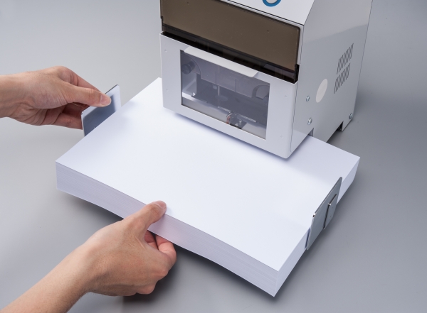 ①センターゲージを広げ用紙を合せる（ＰＰＣ用紙約550枚（50ｍｍ厚）まで穿孔可能）