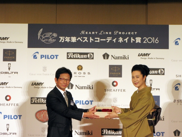 パイロットコーポレーション後藤郁雄代表取締役専務から名取裕子さんに、ナミキ「螺鈿　蛍」を贈呈
