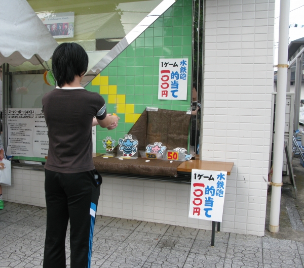 落ち着いて狙ってと、真剣な表情で挑戦する「水鉄砲的当てゲーム」