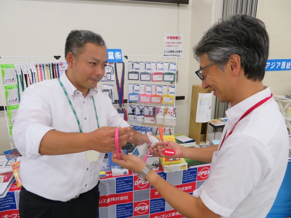 オープン工業ブースでは「『消毒できるストラップ』は医療施設や来客用・貸出用におススメです」と活発な商談