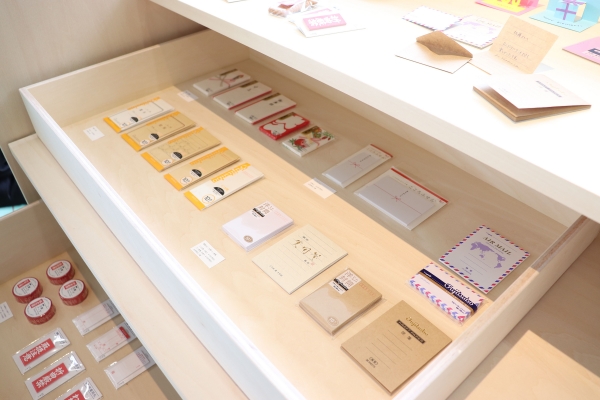 マルアイは　ミニチュア・テーマパーク「SMALL WORLDS TOKYO」にちなみ「藤壺ミニ封筒」「ミニ注意テープ」などの、ミニシリーズを中心に展示