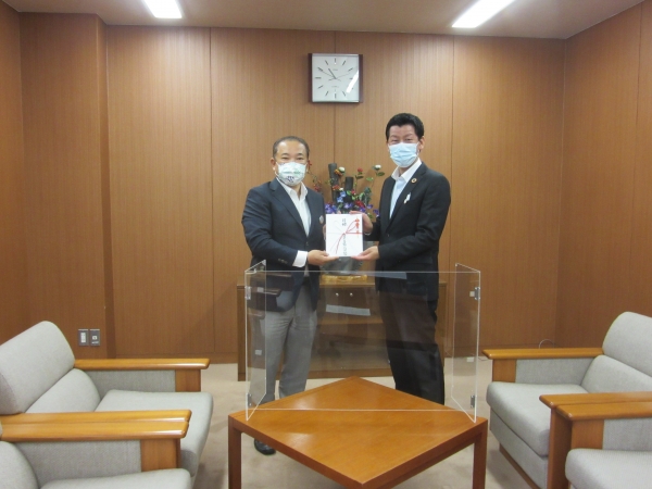 左）本村賢太郎市長　浦上裕生代表理事