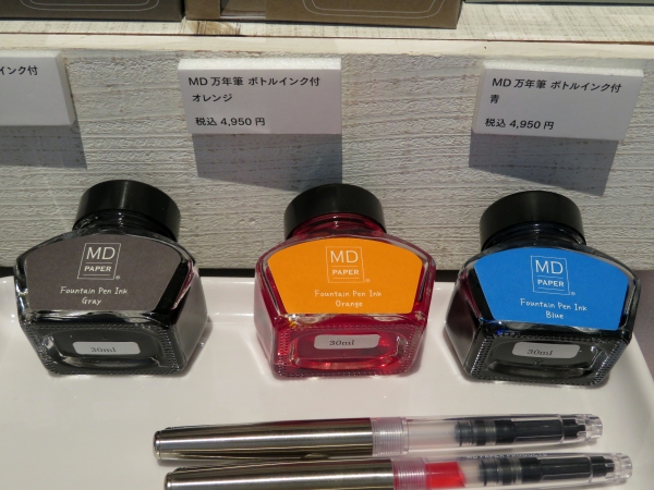 『70 周年限定 MD 万年筆 ボトルインク付』 透明軸の『MD 万年筆』とオリジナルボトルインクの限定セット。オリジナルカラーのインクと、スムーズな書き 心地の万年筆で、あなたの「書く」に寄り添います。
