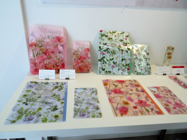 日比谷花壇監修の「クリアファイル」と「マルチケース」新デザイン。ボトルにオイルとともに花をとじこめる ハーバリウム をイメージ。マルチケースは抗菌加工が施されており、マスクケースにもぴったり