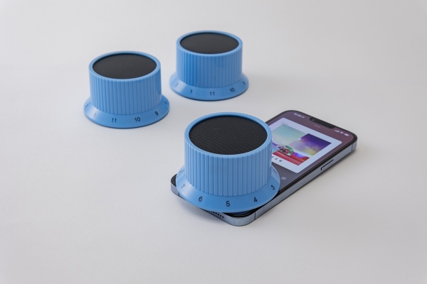 【新生活様式グッズコンテスト準大賞】   出展社名：（株）アライヴ 商品名：ワイヤレススピーカー 商品の特徴：スマートフォンなどに置いて、ダイヤルを回すだけで再生中の音を増幅できます。