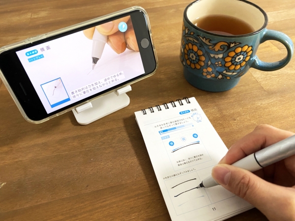 書家・美文字研究家 青山浩之先生が監修し、筆圧コントロールを学びながら自分らしい美しい文字が身に付きます。ボールペンと動画による 1 日 3 分 7 日間のプログラム、コンパクトな練習帳がセットになった練習法