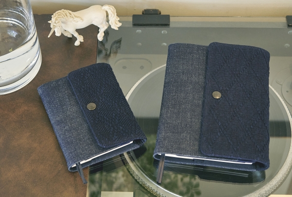 聖林公司のオリジナルブランド『BLUE BLUE（ブルーブルー）』とつくった手帳カバー。丈夫なデニムと、伝統技法「刺し子」をあしらった生地を組み合わせ、異なるふたつの風合いがたのしめるデザイン