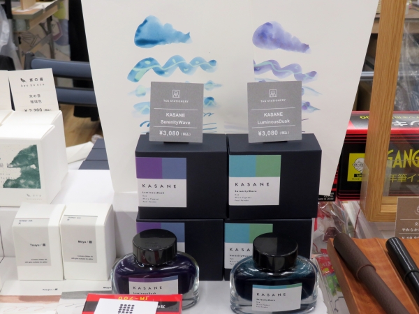 折り重なる色彩。KASANEは、着物の折り重なる色目にインスパイアされた新しいインクシリーズ。「KASANE / SerenityWave」は、平穏と静寂を乗せる波泡の色。青の染料、黄緑の顔料、ブルー系ラメの組み合わせ。「KASANE / LuminousDusk」は、夜と朝が交差する一瞬の黄昏、星と太陽が輝き重なり合う色彩。紫の染料、青の顔料、ゴールドラメの組み合わせ。　TAG STATIONERY