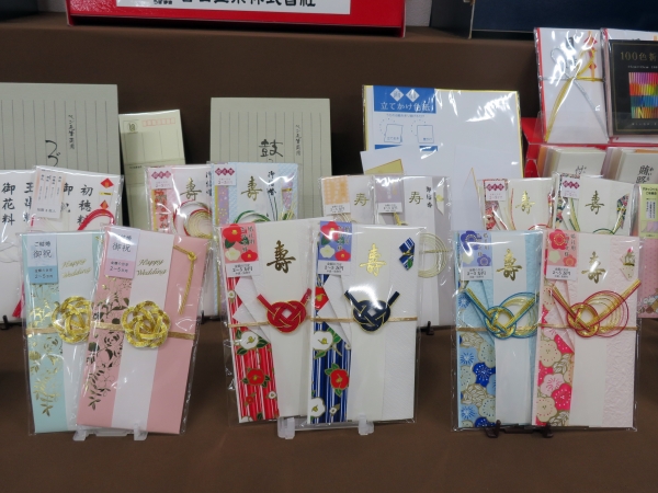 キラキラしたお花の箔押しが綺麗な金封「スリム金封 flower」と吉祥文様の梅と椿の友禅紙を使用した婚礼用金封　菅公工業