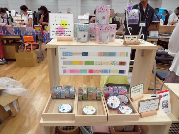 ㈱ミワックスのマスキングテープホルダー「ＭＡＳＵＨＯ」のテーマは あなたの推しを、いつでもそばに。お気に入りのマスキングテープを3巻入れて、自由に組み合わせてオリジナルチャームを作りバッグに取り付けて持ち歩くことができます！